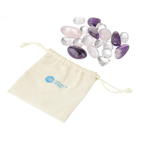 Mehrere polierte Edelsteine in Lila-, Rosa- und Klartönen liegen neben einem beigen Stoffbeutel mit Zugband und Logo.