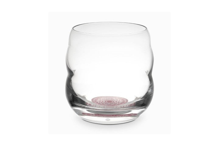 Ein klarer Mythos Becher mit geschwungener Form, am Boden ein rotes Chakra- oder Affirmationssymbol, auf weißem Hintergrund.