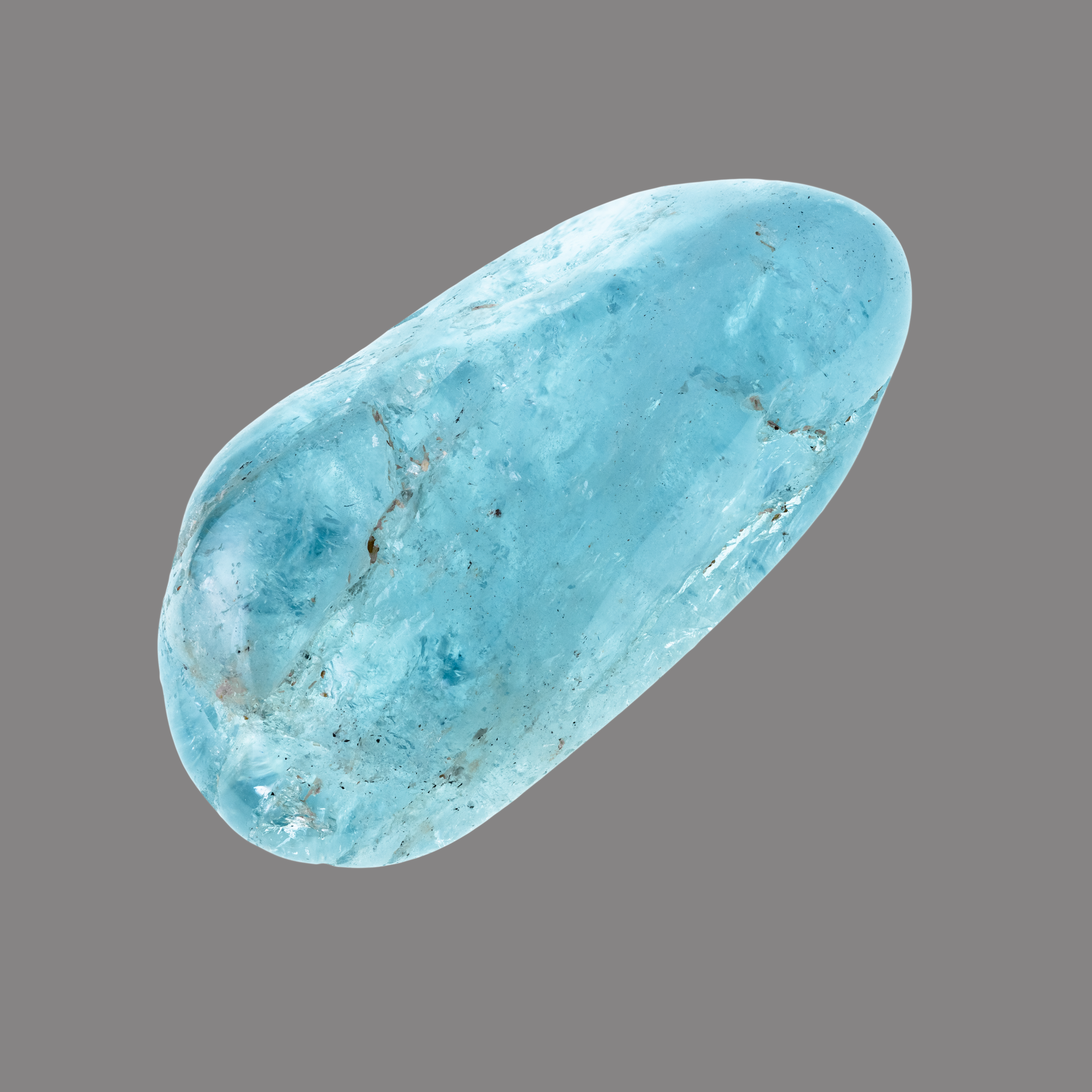 Ein glatter, länglicher, polierter Edelstein in leuchtendem Hellblau mit feinen Einschlüssen und transparentem Glanz.