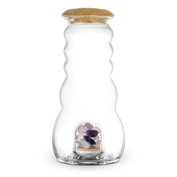 Bauchige, klare Cadus Karaffe 1,5 Liter mit Holzdeckel; im Boden gläserne Kammer mit lila und rosa Edelsteinen sichtbar.