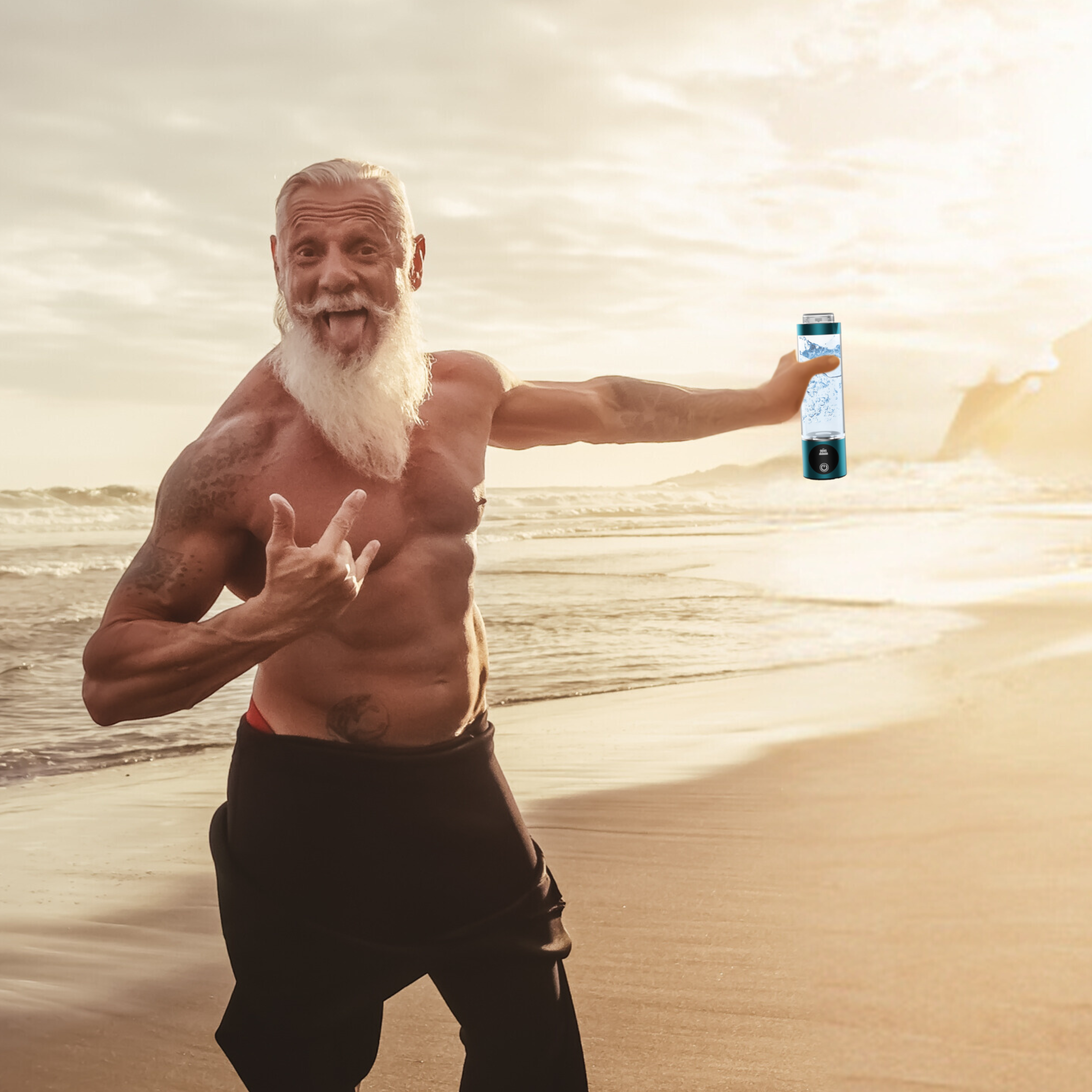 Ein älterer, muskulöser Mann mit weißem Bart posiert lachend am Strand, hält einen Wasserionisierer in der rechten Hand.