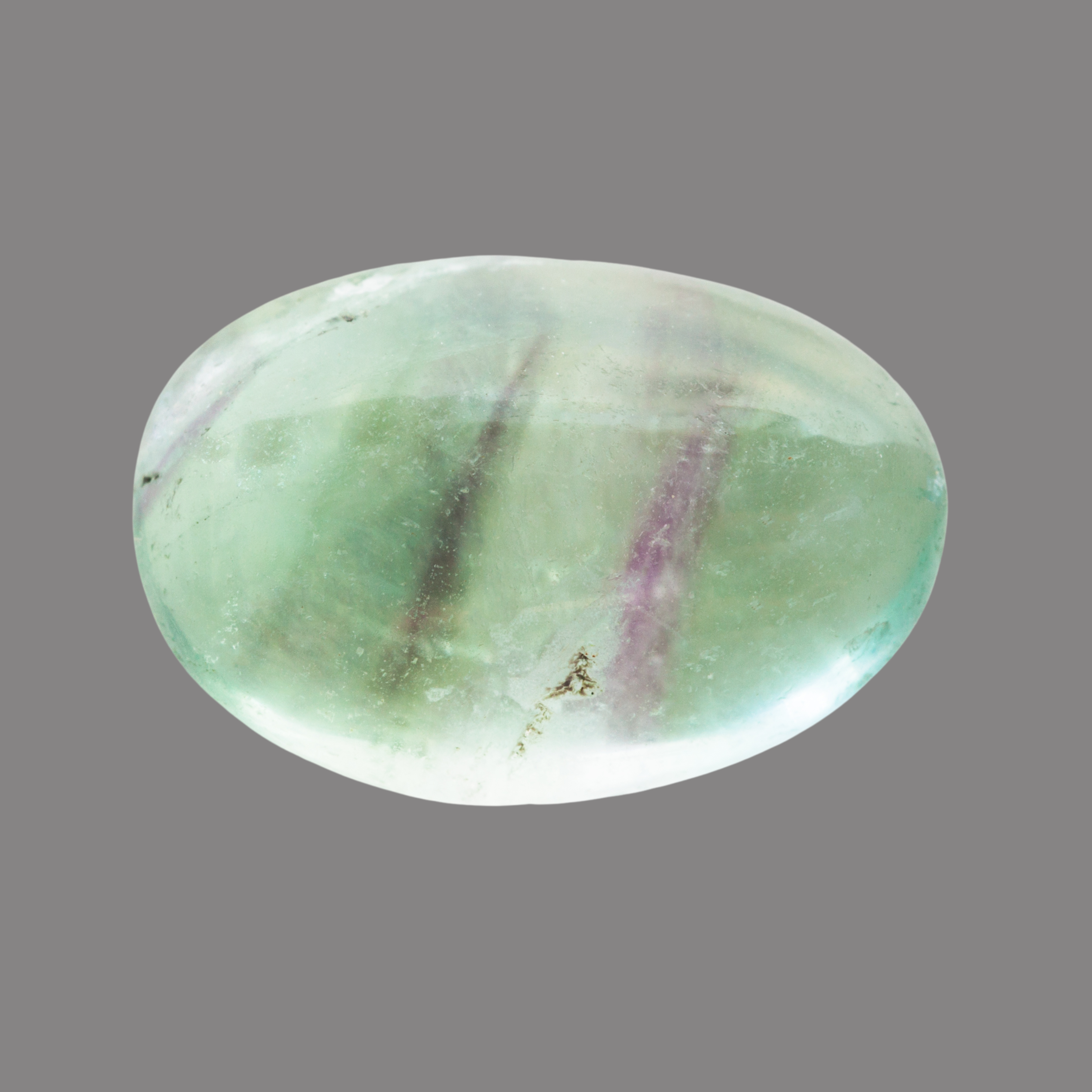 Ein glatter, ovaler Edelstein in Pastellgrün mit violetten und weißen Einschlüssen, leicht transparent und poliert.