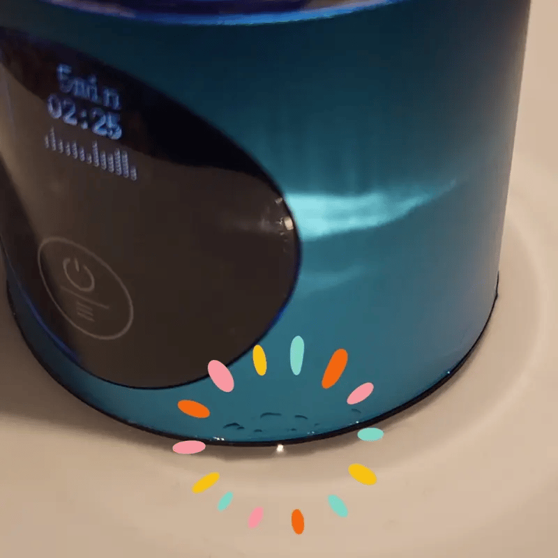 Ein blauer, zylindrischer elektrischer Luftbefeuchter mit digitaler Anzeige, Ein/Aus-Taste und Wassertropfen an der Basis.