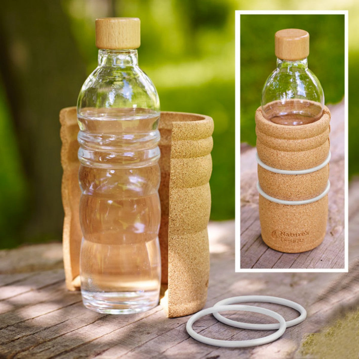 Eine klare Lagoena Trinkflasche aus Glas mit Holzdeckel steht teilweise in einem Korkschutz, daneben zwei weiße Gummiringe.
