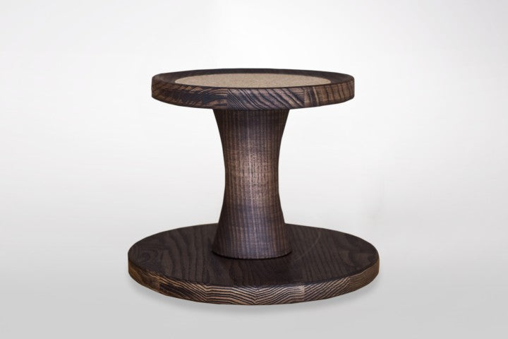 Ein Unterbau aus dunkler Esche-Holzoptik, rundes Design mit breitem Sockel, mittlerer Säule und ebenfalls rundem Oberteil.